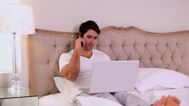 침대에서 일 하는 행복 한 잘생긴 남자 — 비디오
