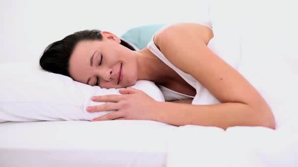 Vreedzame aantrekkelijke vrouw slaapt in haar bed liggen — Stockvideo