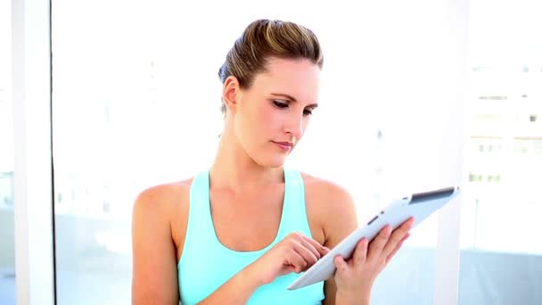 Lachende vrouw met behulp van haar digitale tablet passen — Stockvideo