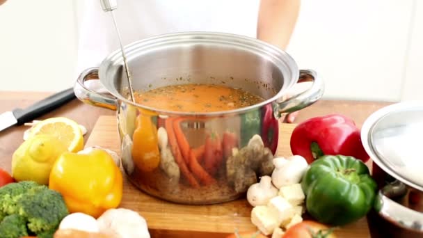 Woman stirring soup and adding mushrooms — Stock Video