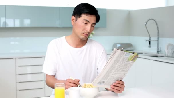 Hombre atractivo comiendo cereal y leyendo revista — Vídeo de stock