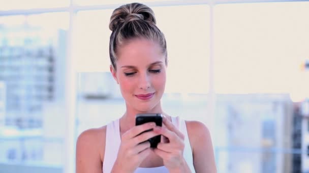 Cute young woman text messaging with her smartphone — Stock Video