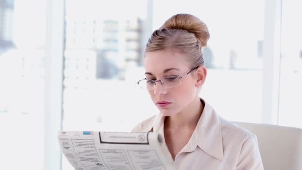 Content blonde businesswoman reading newspaper — Stock Video