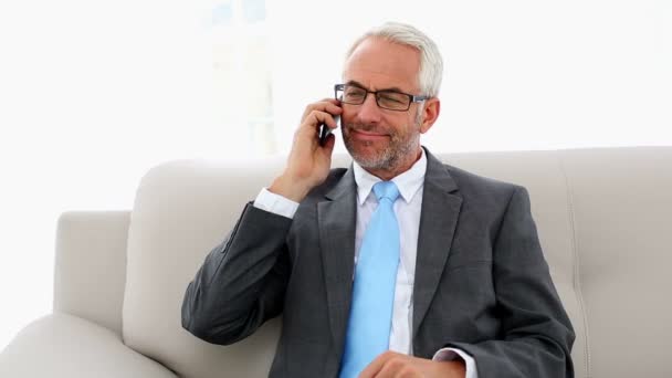 Businessman talking on the phone on the couch — Stock Video