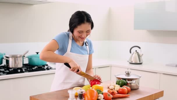 usmívající se žena krájení zeleniny s velkým nožem