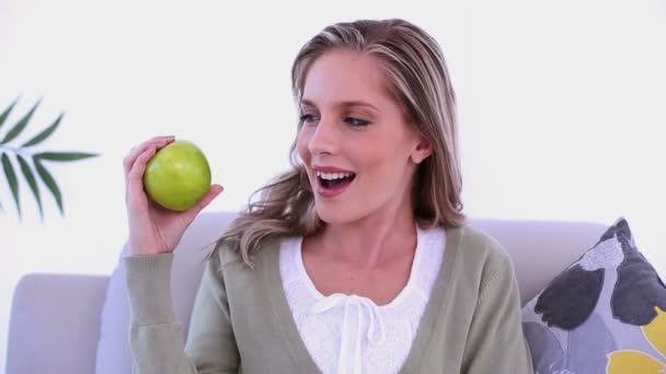 Χαρούμενα όμορφη γυναίκα που δείχνει ένα πράσινο μήλο — Αρχείο Βίντεο