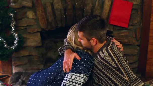 Linda pareja celebrando la Navidad juntos en frente de la chimenea — Vídeos de Stock