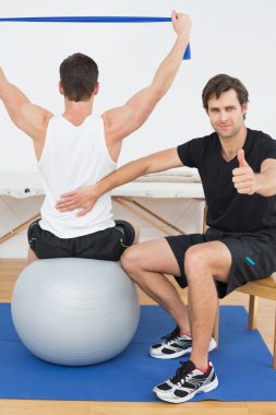terapist jestleri başparmak yukarıya yanında yoga topu on adamım