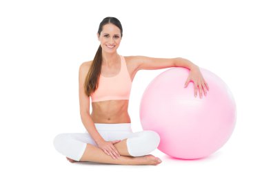 gülümseyen fit fitness topu ile oturan genç kadın