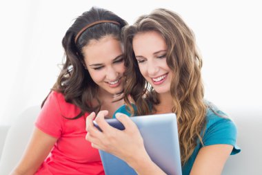 iki genç arkadaşlar dijital tablet kullanarak gülümseyen