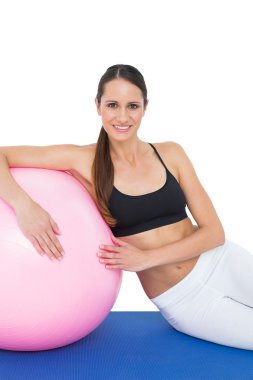 fitness topu ile oturan gülümseyen uygun bir Bayan portresi