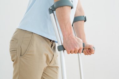 orta bölümde bir adamın koltuk değneği ile yan görünüm