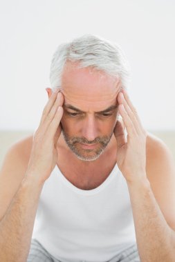 yatakta baş ağrısı çeken adam