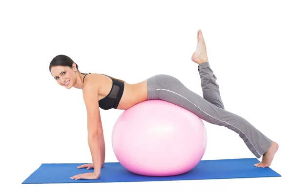 Retrato de vista lateral de una mujer en forma estirándose sobre una pelota de fitness —  Fotos de Stock