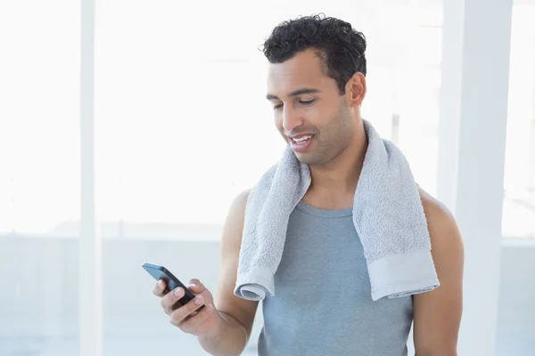 Young smiling man looking at mobile phone — Stock Photo, Image