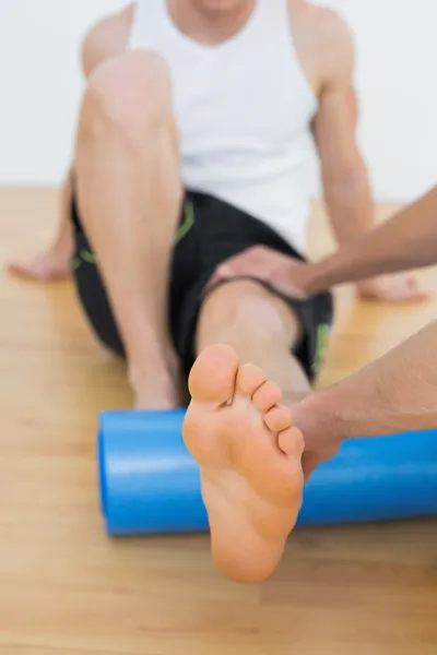 Physical therapist examining a young mans leg — Stock Photo, Image