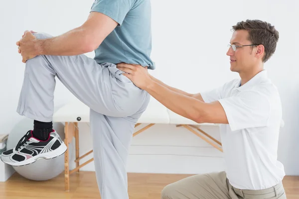 Therapeut masseren mans lagere terug in gym ziekenhuis — Stockfoto