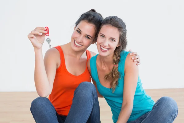 Friends with house keys sitting on the floor — Stock Photo, Image