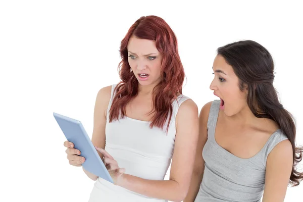 Chockad kvinnliga vänner tittar på digital tablet — Stockfoto