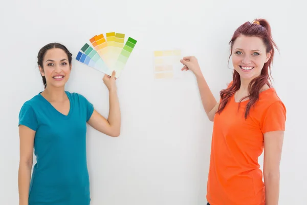Amigos escolhendo cor para pintar uma sala — Fotografia de Stock