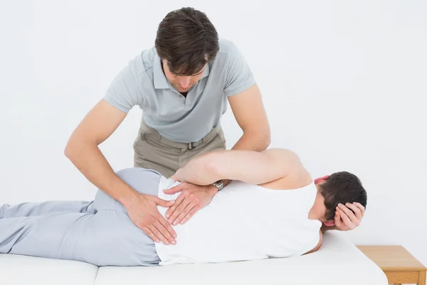 Fisioterapeuta masculino examinando paciente — Fotografia de Stock