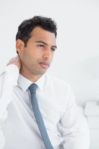 Businessman suffering from neck pain in bed — Stock Photo, Image