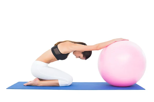 फिटनेस बॉल के साथ व्यायाम करने वाली एक फिट महिला का साइड व्यू — स्टॉक फ़ोटो, इमेज