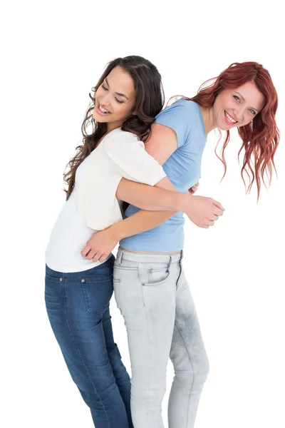 Young women standing back to back with interlocked hands — Stock Photo, Image