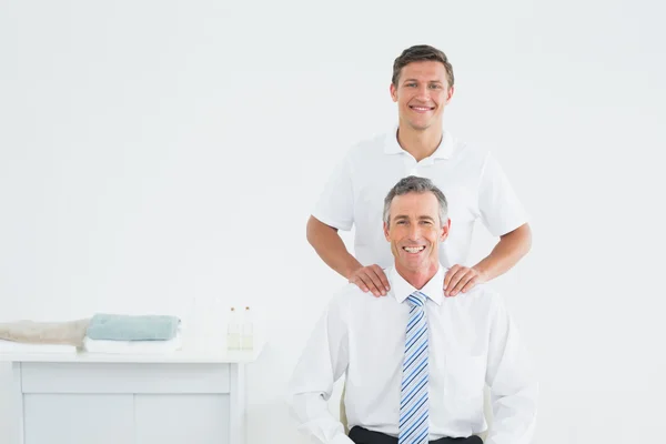 Mannelijke chiropractor en goed geklede volwassen patiënt — Stockfoto