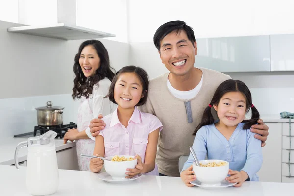 Familj på fyra med frukost i köket — Stockfoto