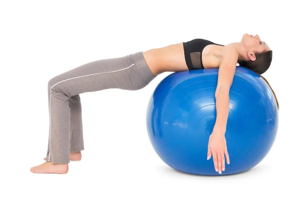 Sidovy av en vältränad kvinna stretching på fitness boll — Stockfoto