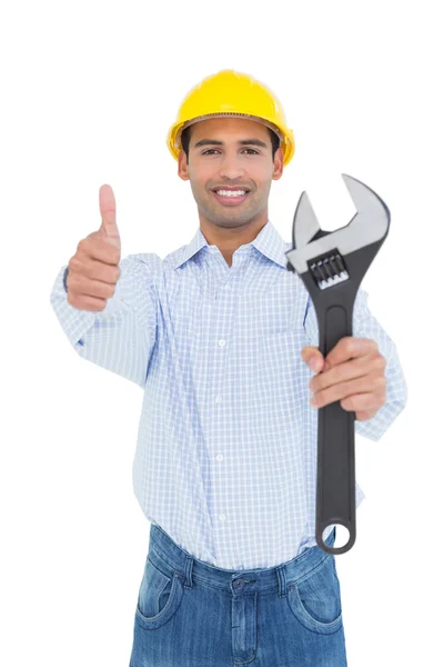 Handyman sosteniendo una llave inglesa mientras hace gestos con los pulgares hacia arriba —  Fotos de Stock