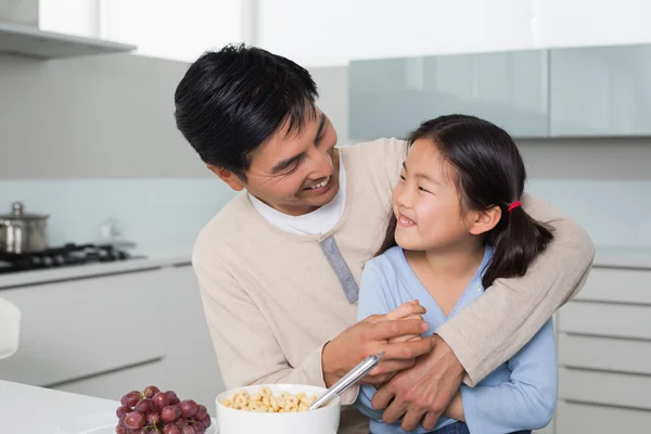 Cheerful father with daughter having cereals in kitchen — Stock Photo, Image