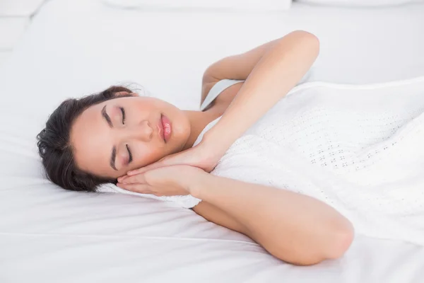 Hübsche junge Frau schläft mit geschlossenen Augen im Bett — Stockfoto