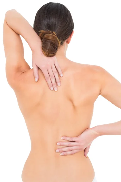 Vista posteriore di una giovane donna in topless in forma con mal di schiena — Foto Stock