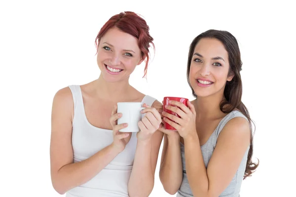 Две улыбающиеся девушки с кофейными чашками — стоковое фото