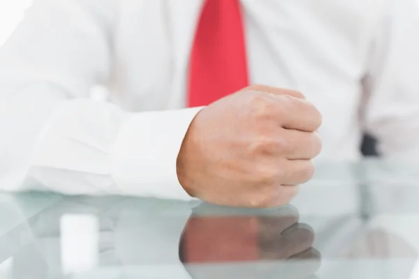 Mid section of a businessman with clenched fist on desk — Stock Photo, Image