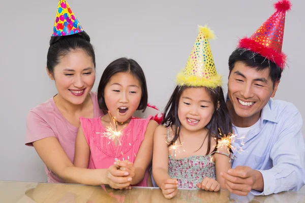 Fröhliche vierköpfige Familie spielt mit Feuerwerkskörpern — Stockfoto