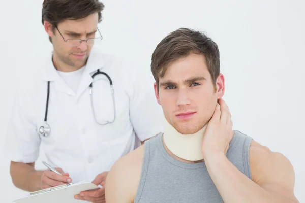 Médico masculino examinando um pescoço de pacientes — Fotografia de Stock