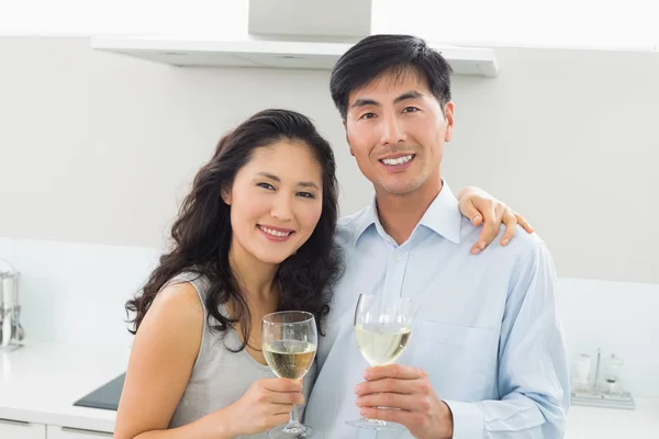 Loving young couple with wine glasses in kitchen — Stock Photo, Image