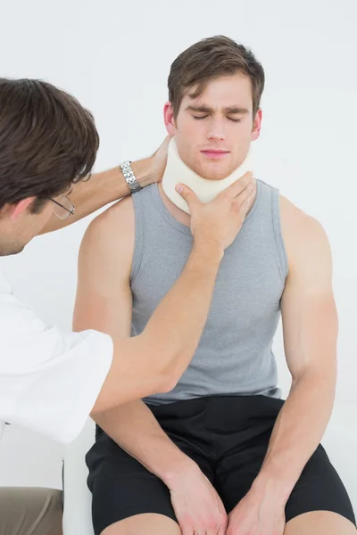 Arzt untersucht Hals eines Patienten — Stockfoto