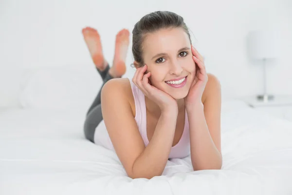 Lächelnde hübsche junge Frau entspannt sich im Bett — Stockfoto