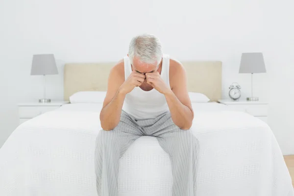 Thoughtful mature man sitting in bed — Stock Photo, Image