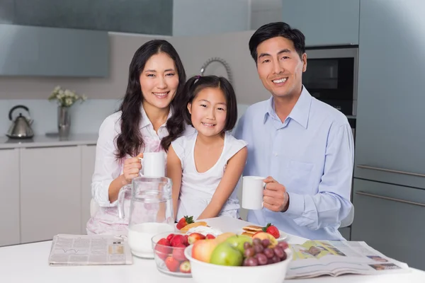 Gelukkig jong meisje genieten van ontbijt met ouders — Stockfoto