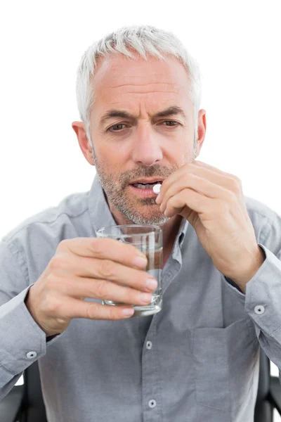 Primo piano di un uomo maturo con bicchiere d'acqua e pillola — Foto Stock