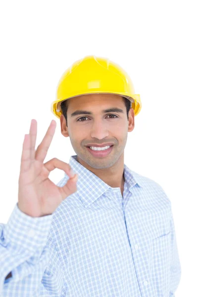 Smiling handyman in yellow hard hat gesturing okay sign — Stock Photo, Image