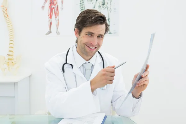 Médico masculino concentrado a olhar para a imagem de raio-X da coluna vertebral — Fotografia de Stock