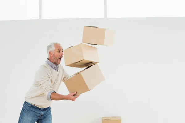 Side view of a mature man carrying boxes — Stock Photo, Image