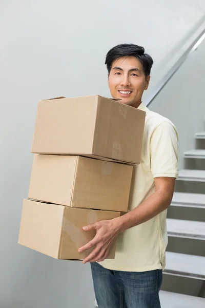 Portrét smějící se mladý muž nesoucí krabice — Stock fotografie