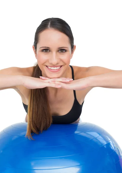 Retrato de una mujer sonriente en forma estirándose sobre una pelota de fitness —  Fotos de Stock